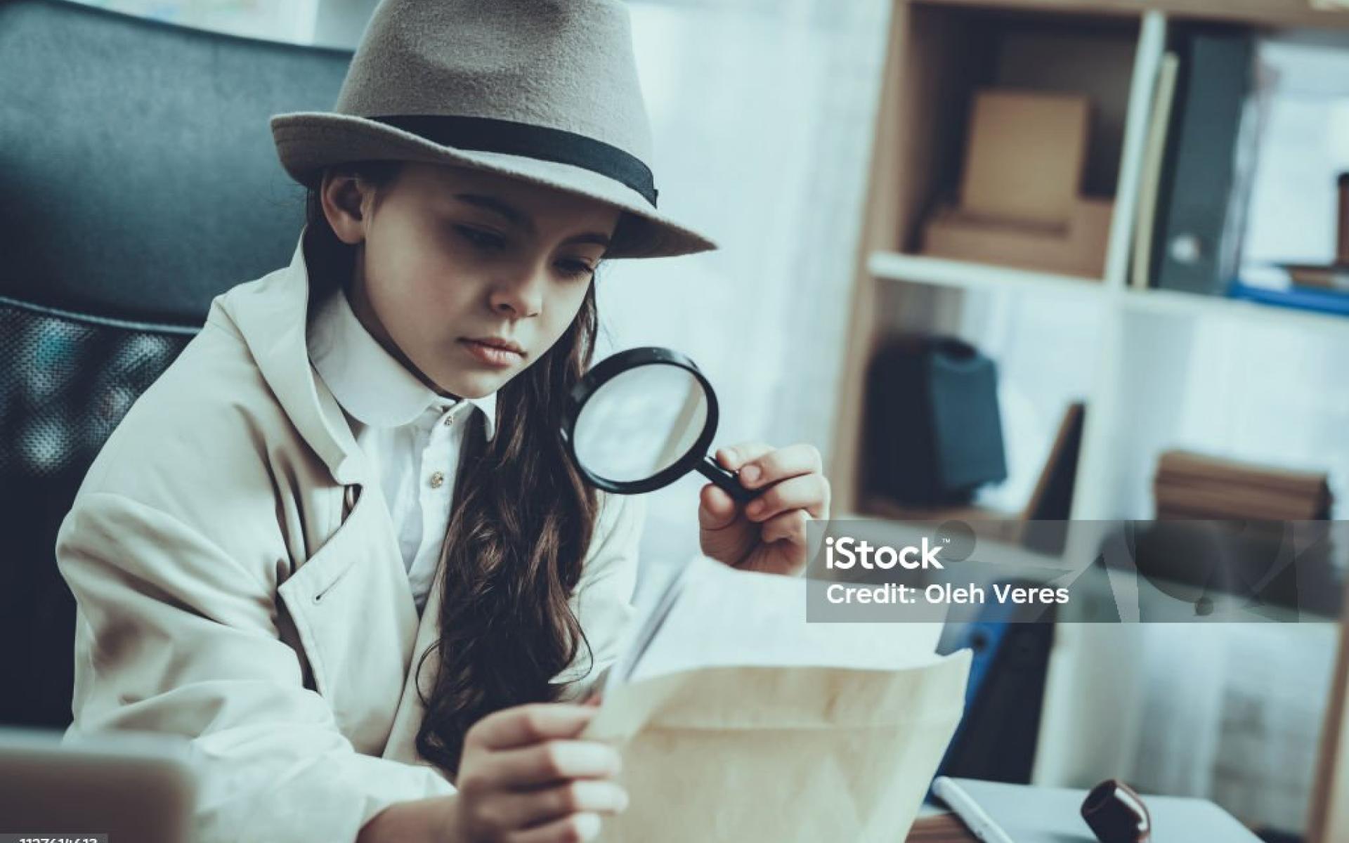 Mädchen mit Lupe und Zettel