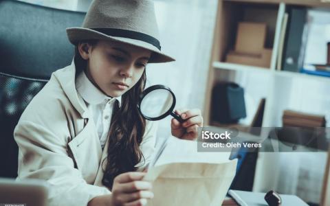 Mädchen mit Lupe und Zettel